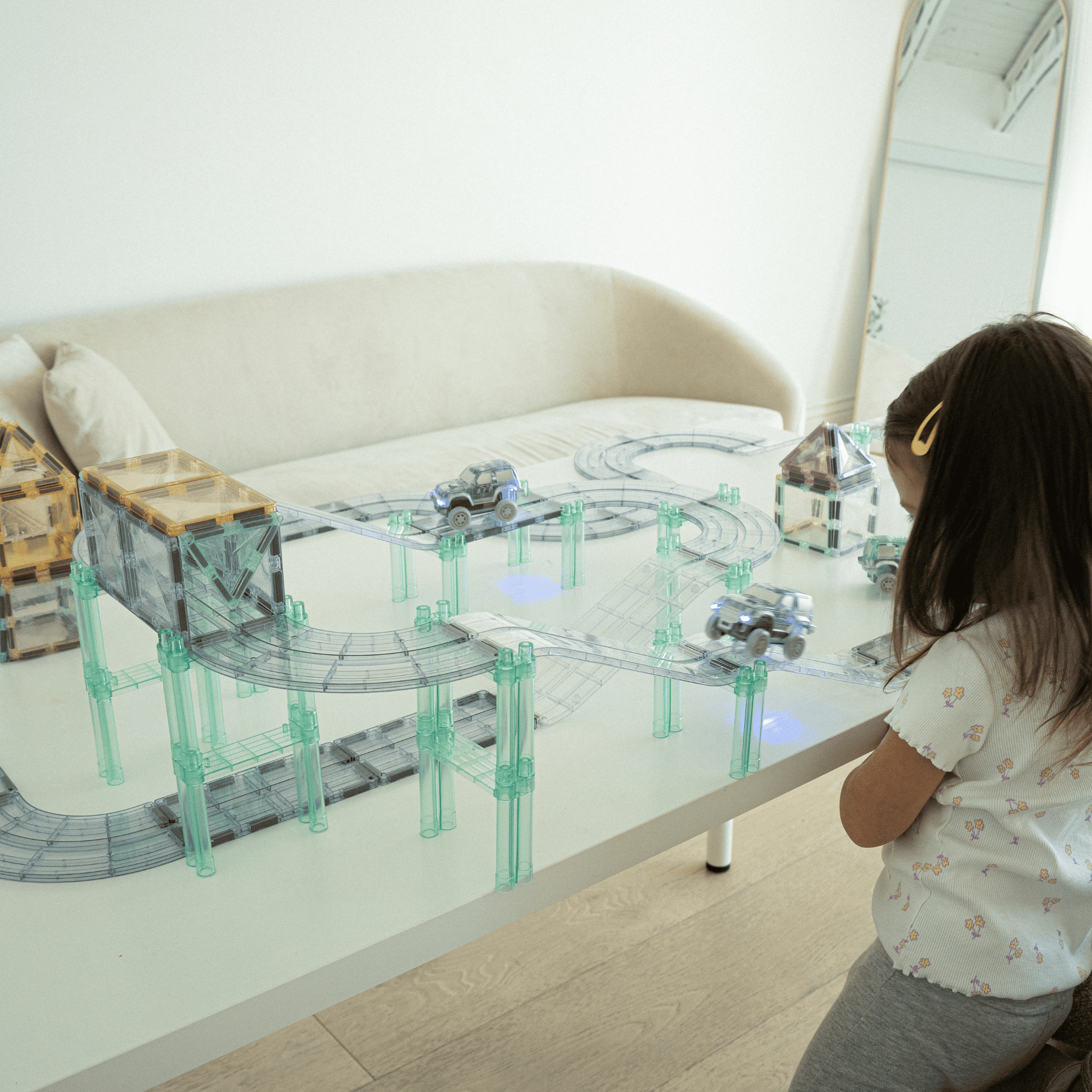 Children racing cars on magnetic tile track