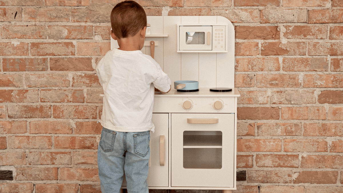 Modern play kitchen for kids in neutral playroom setting