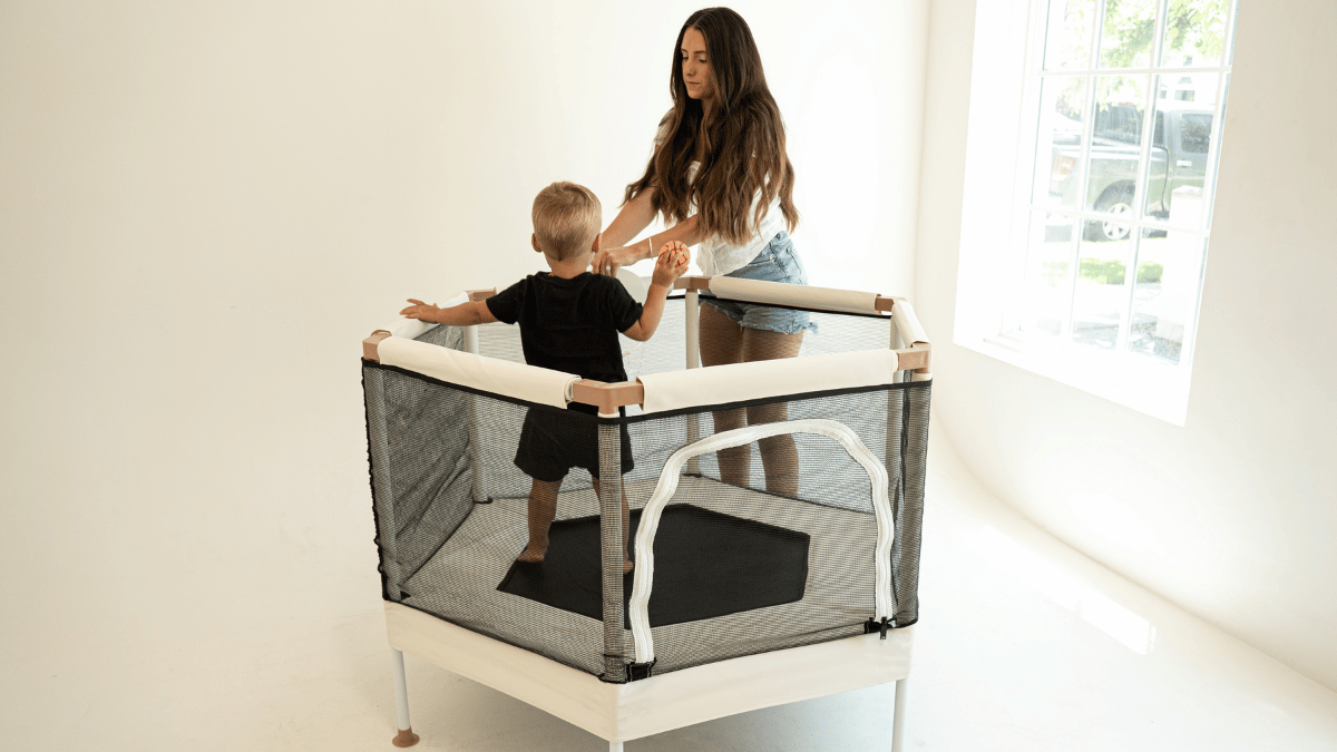 Modern trampoline in playroom toddler playing with mother